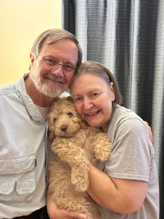 Older couple enjoying time with their Labradoodle