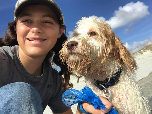 Young girl with braces smiling with her Australian Labradoodle